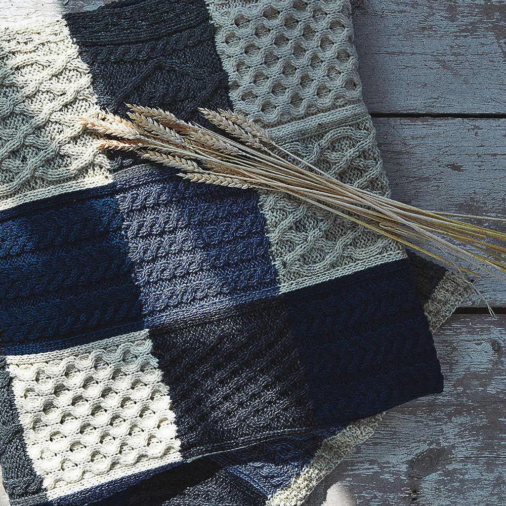 Aran Woollen Mills blue patchwork blanket closeup with wheat