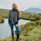 Woman wearing charcoal herringbone poncho with buttons