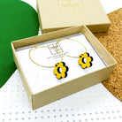 Yellow wooden daisy hoop earrings in a box